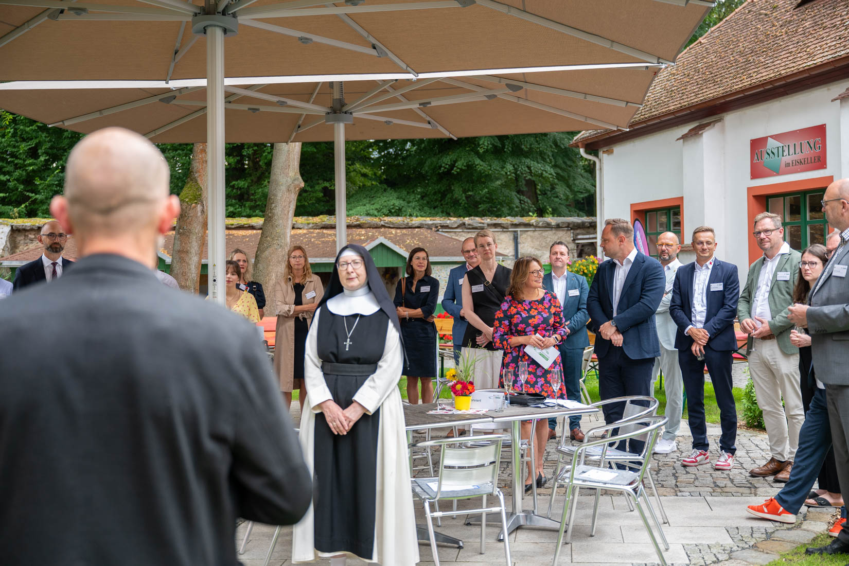 Gäste der Veranstaltung folgen dem Geschehen auf der Bühne