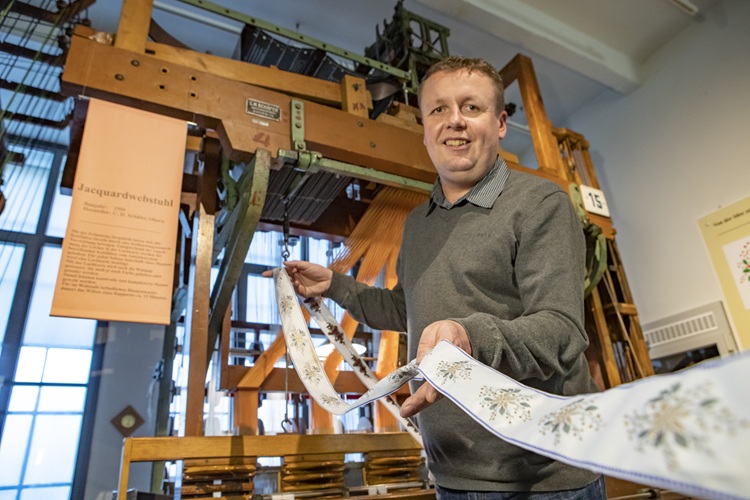 Patrick Zöllner vom Bandwebermuseum präsentiert eines im Museum gewebten Bandes
